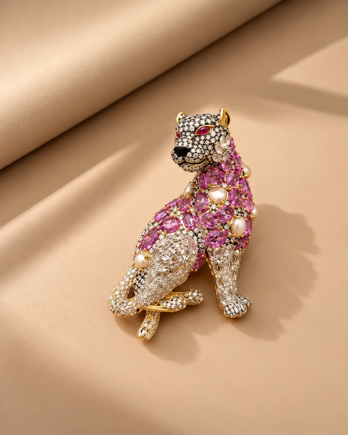 Leopard-shaped jewellery piece with pink stones and white details on a warm beige set